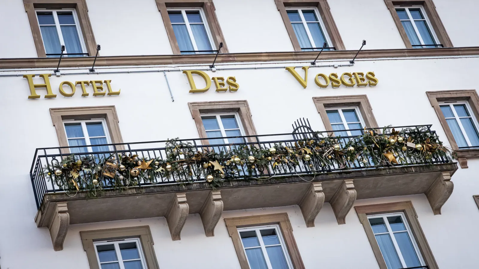 Façade d'un hôtel avec une balustrade décorée de guirlandes et d'étoiles dorées