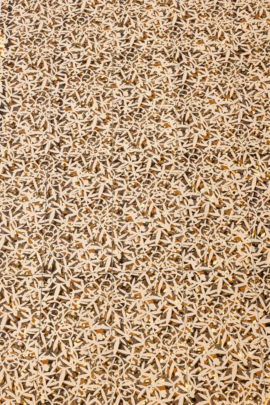 Une multitude de petits personnages blancs en bois est disposée sur un fond brun clair